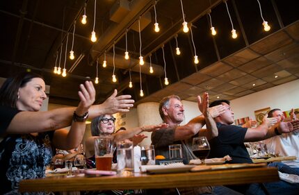 Audience members participate in a magic trick by magician Trigg Watson at Checkered Past...