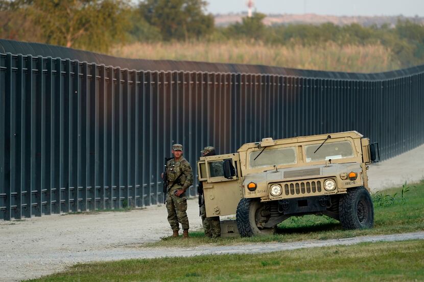 National Guardsmen stands watch over a fence near the International bridge where thousands...