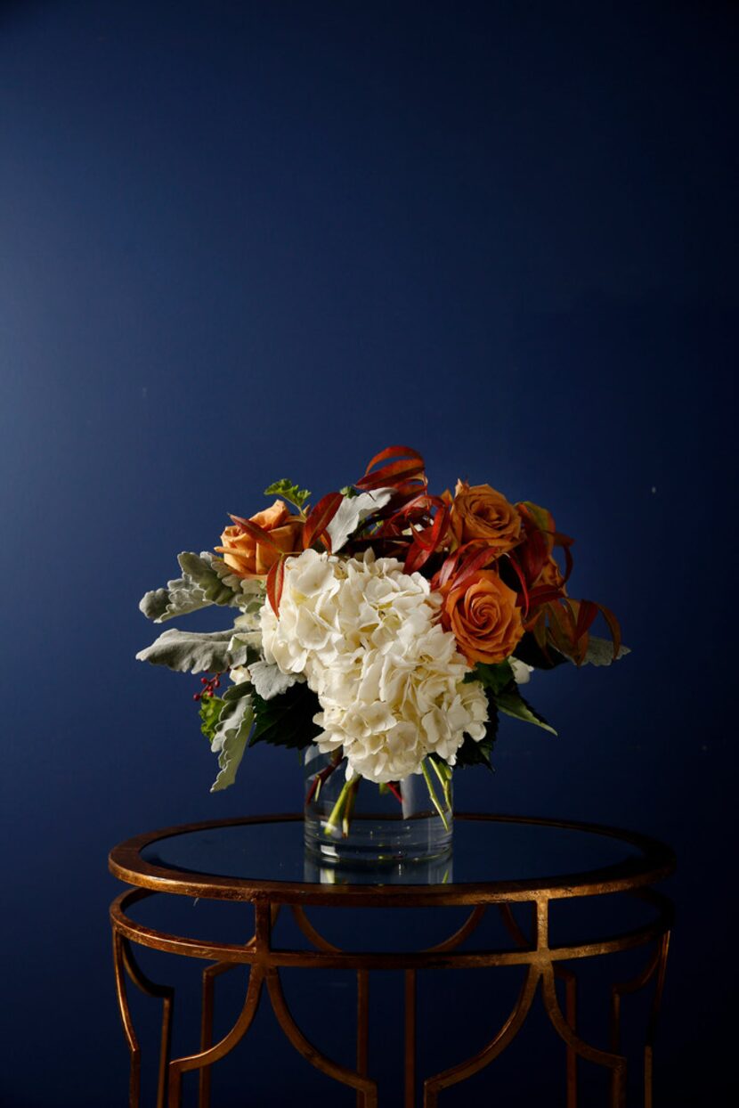 Floral arrangement including hydrangeas, Combo rose, geranium leaves, dusty miller and...