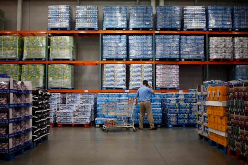 
A customer shops for bottled water at a Costco store in Louisville, Ky. Warehouse clubs’...