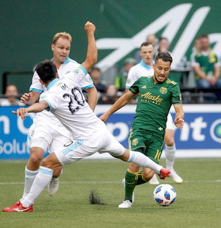 Portland Timbers' Sebastian Blanco (10) tries to get the ball past Seattle Sounders' Kim...