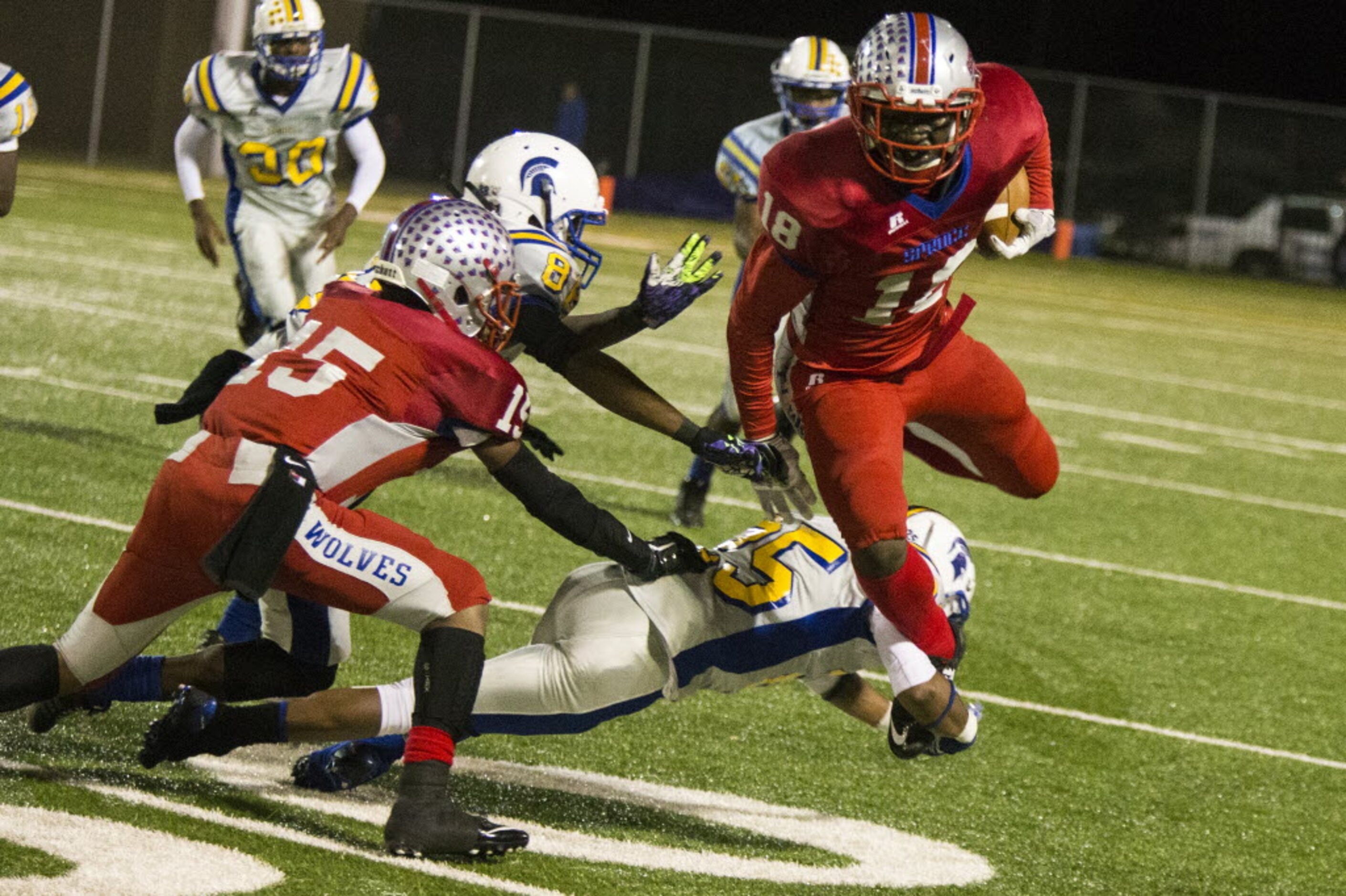 Spruce's Kendric Ford (18) hurdles through the defense during W. W. Samuell's matchup...