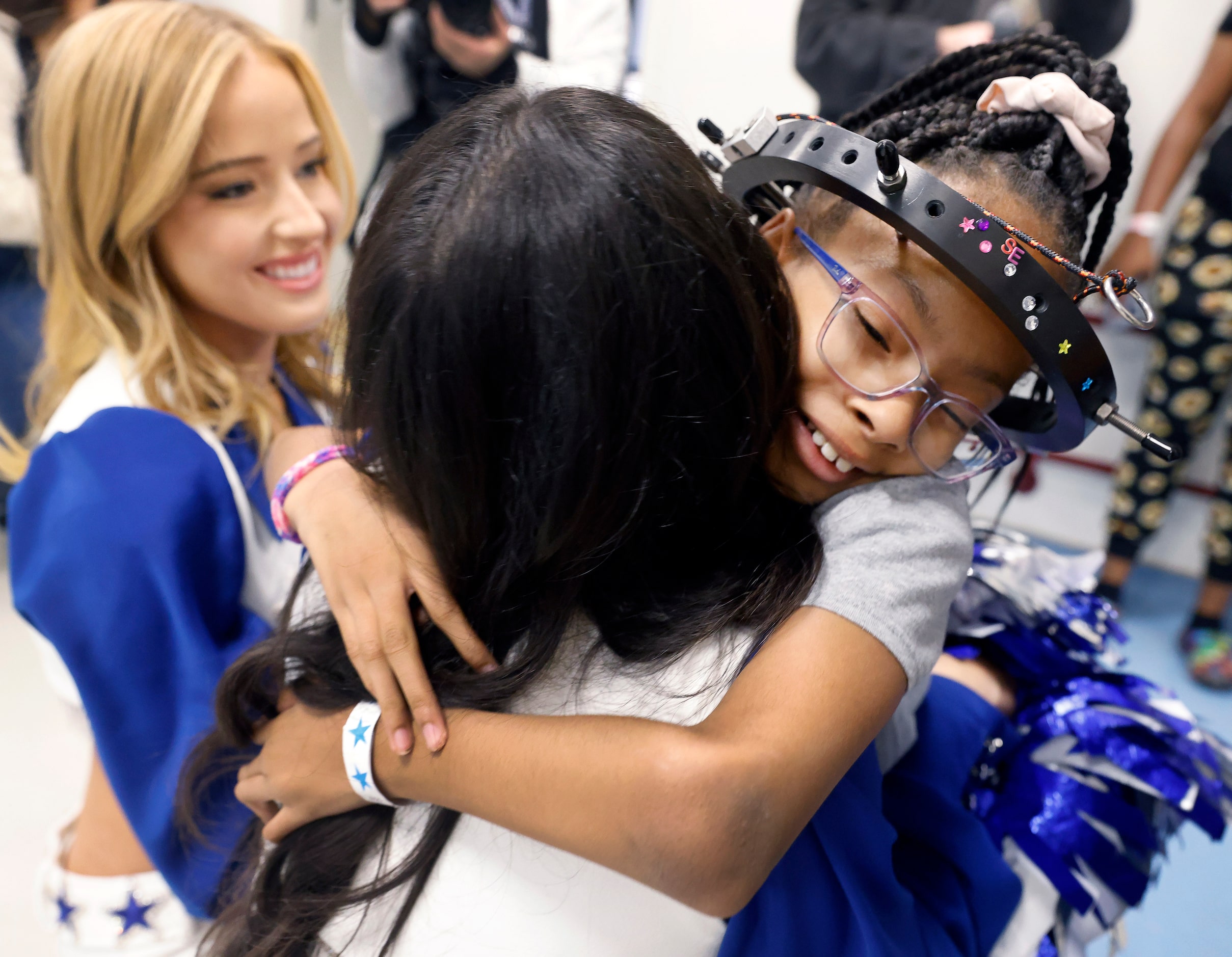 Serenitee Jackson gives Dallas Cowboys Cheerleader Chandi McCright a hug after learning how...