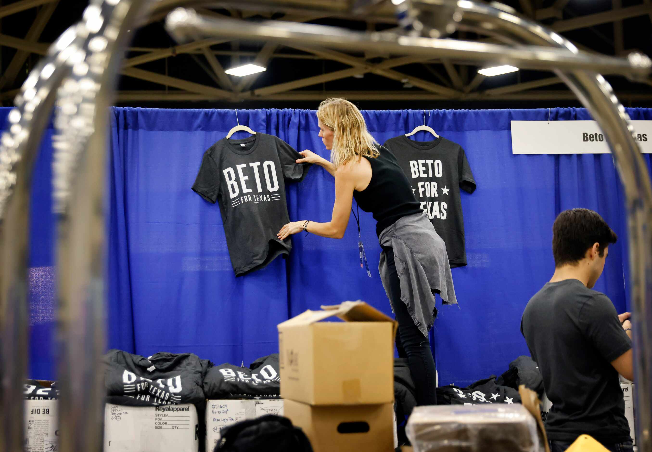 Staffer Chrissy Kleberg hangs up Beto For Texas t-shirts at his booth as the team set up on...