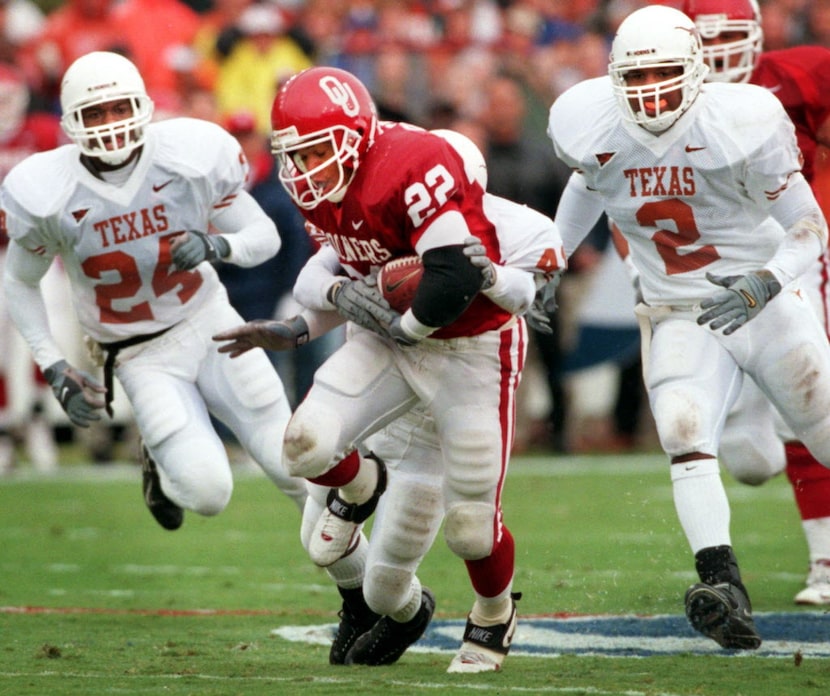 OU's RB Quentin Griffin (22) tears through the Texas defense and past defenders Greg Brown...