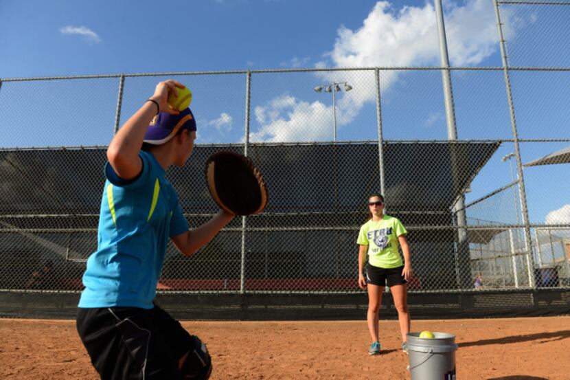 Lya Swaner gives softball lessons to Alex Guillory, 11, at Founders Park in Wylie. Swaner,...
