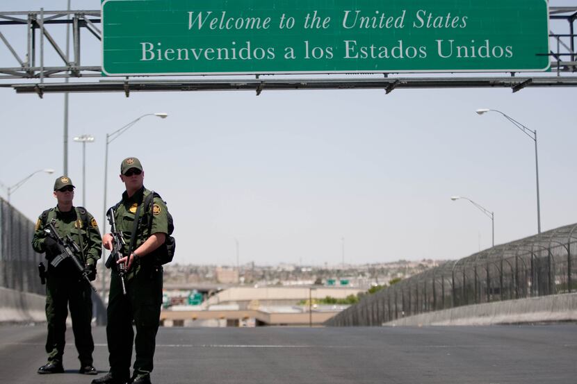 U.S. Customs and Border Protection agents stand guard at the center of the Bridge of...
