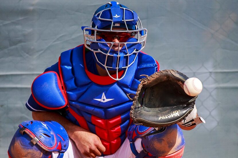 Texas Rangers catcher/infielder Isiah Kiner-Falefa catches a bullpen session during a spring...