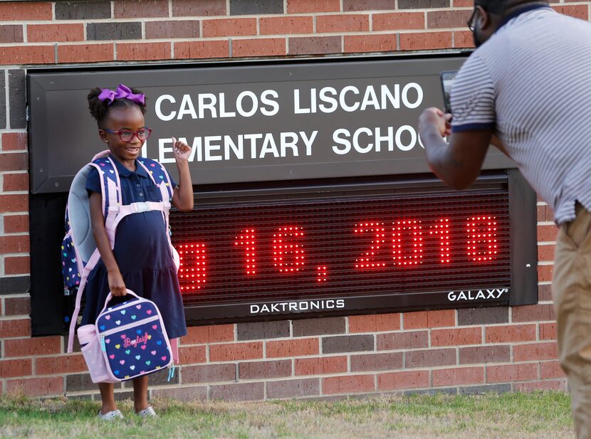 Kindergartner Bayleigh Briggs gets her photo taken by her dad, Chris Briggs, in front of the...