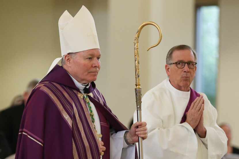 Bishop Edward J. Burns processes to the altar alongside Deacon John OÃLeary during a...