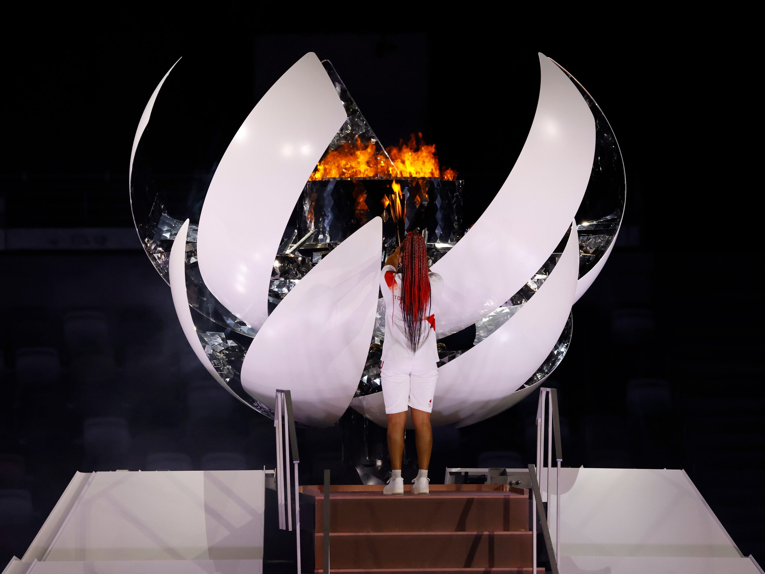 Naomi Osaka lights the Olympic cauldron during the opening ceremony for the postponed 2020...