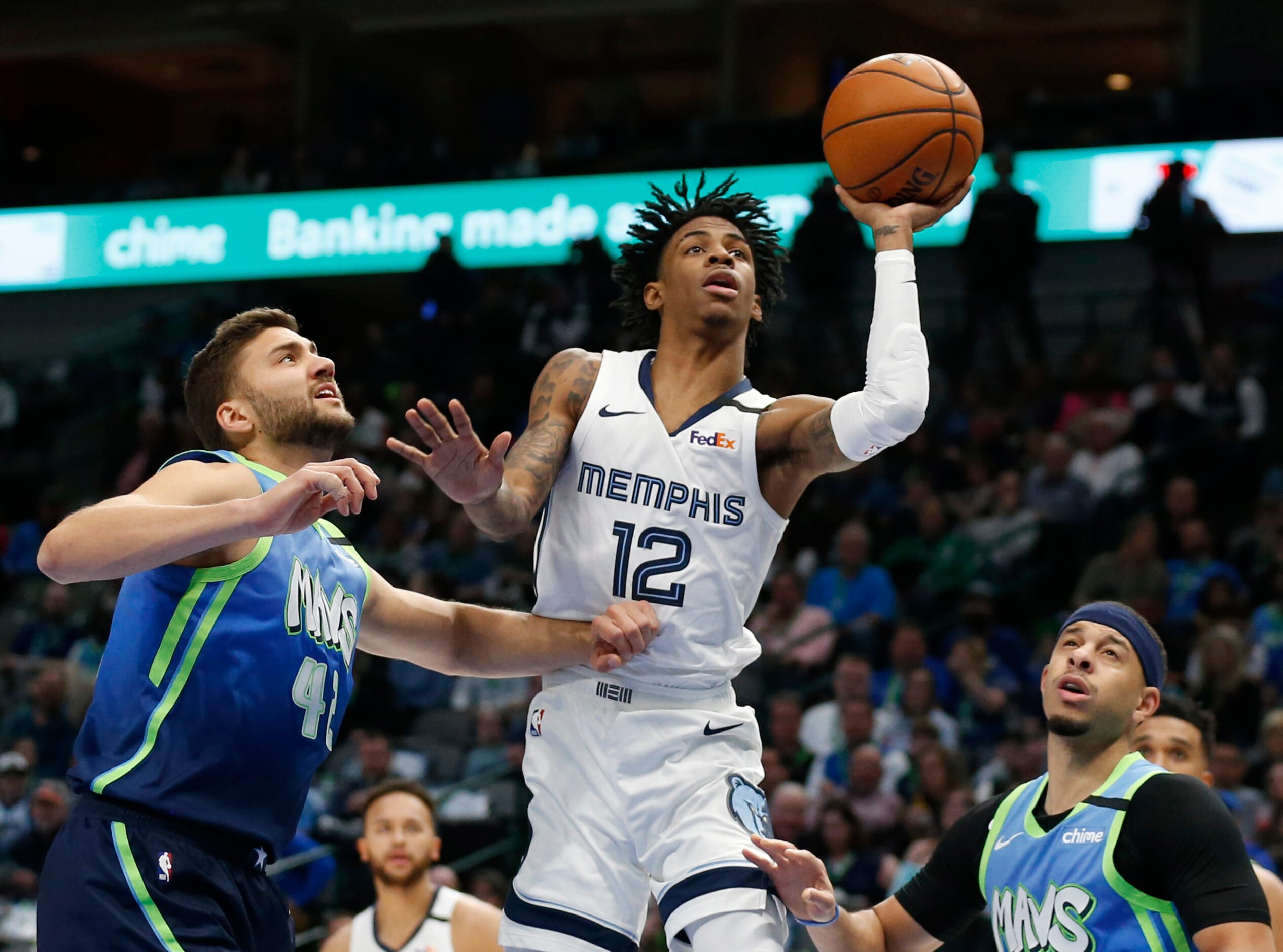 Memphis Grizzlies guard Ja Morant (12) attempts a shot in between Dallas Mavericks forward...