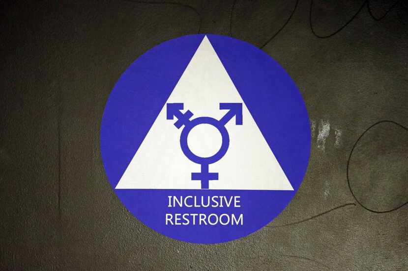 FILE - In this May 17, 2016, file photo, a new sticker designates a gender neutral bathroom...