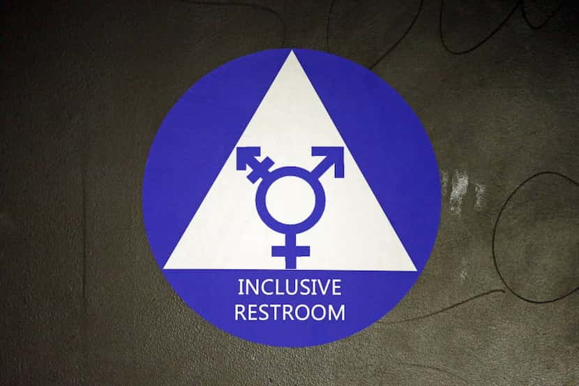 FILE - In this May 17, 2016, file photo, a new sticker designates a gender neutral bathroom...