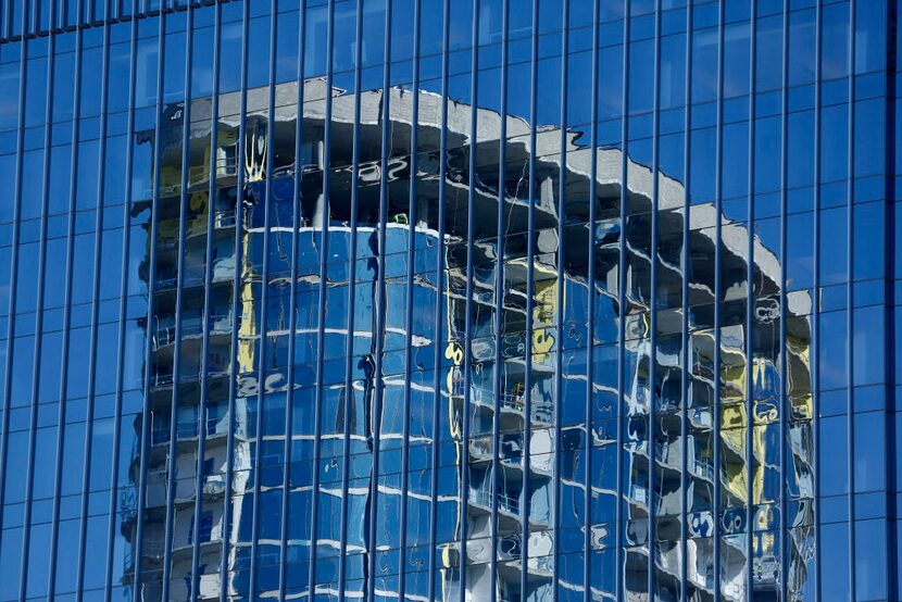 A luxury apartment tower under construction in the Legacy West area of Plano is reflected...