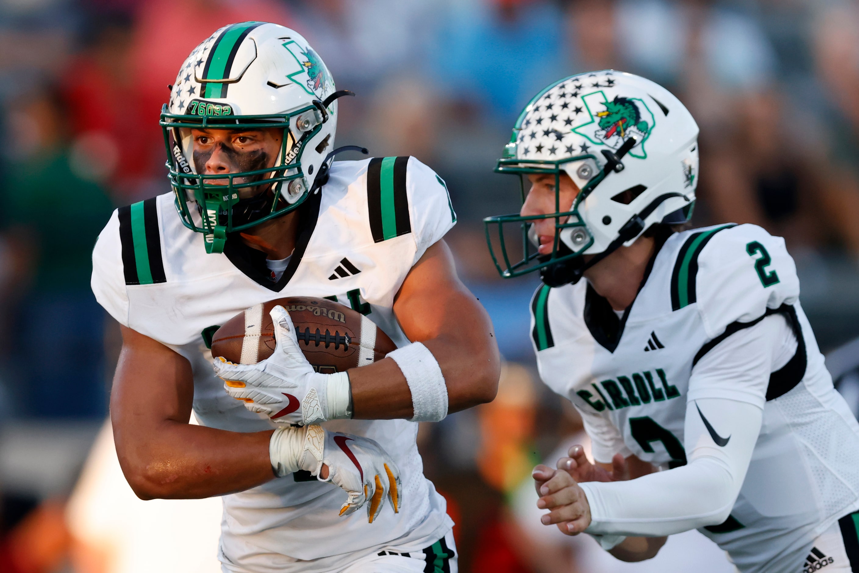 Southlake Carroll quarterback Angelo Renda (2) hands the ball off to running back Riley...