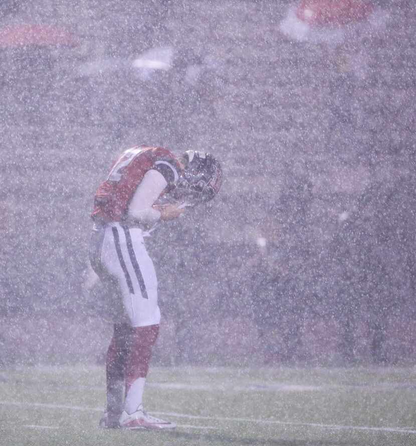 McKinney Boyd quarterback Grant Restmeyer (12) wipes his helmet as rain falls in the second...