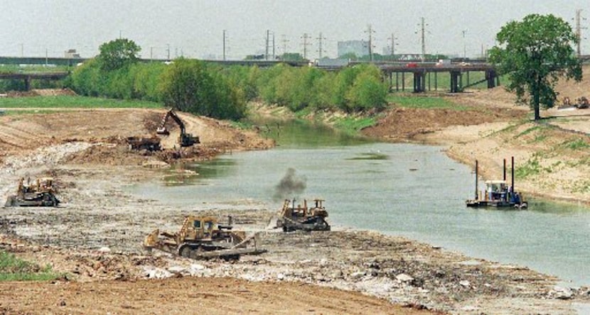 Construction workers dig out the  Trinity River channel north of the Corinth Street Viaduct...