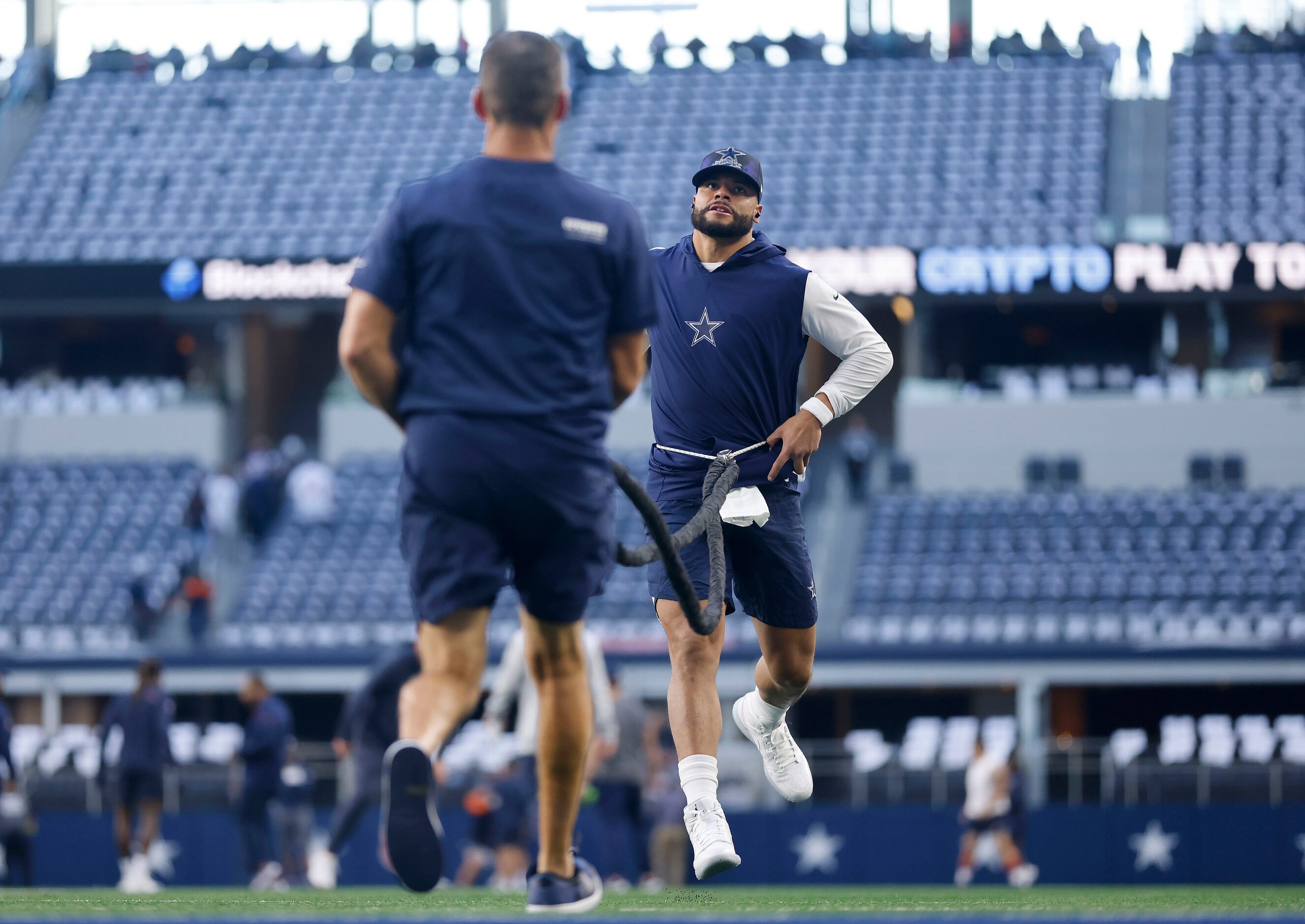 Dallas Cowboys quarterback Dak Prescott (4) stretches on a resistance cord before their game...