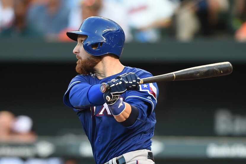 BALTIMORE, MD - AUGUST 03:  Jonathan Lucroy #25 of the Texas Rangers singles in Rougned Odor...