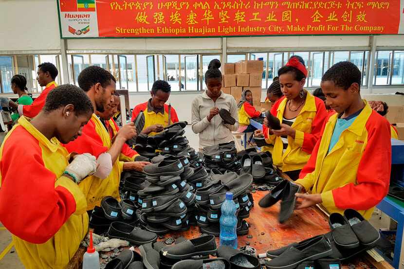 In this January photo,  Ethiopian factory workers sort through shoes at the Chinese company...