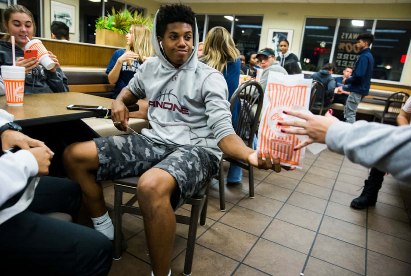 Reedy High School student Mike McKenzie, 16, receives a bag of food from a Lone Star High...