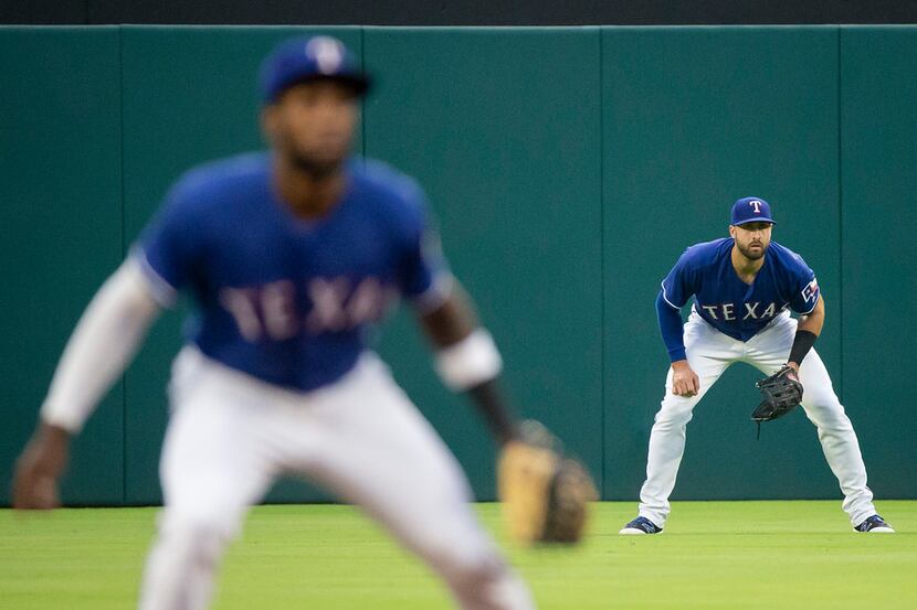 Texas Rangers center fielder Joey Gallo (right) takes his position behind shortstop...