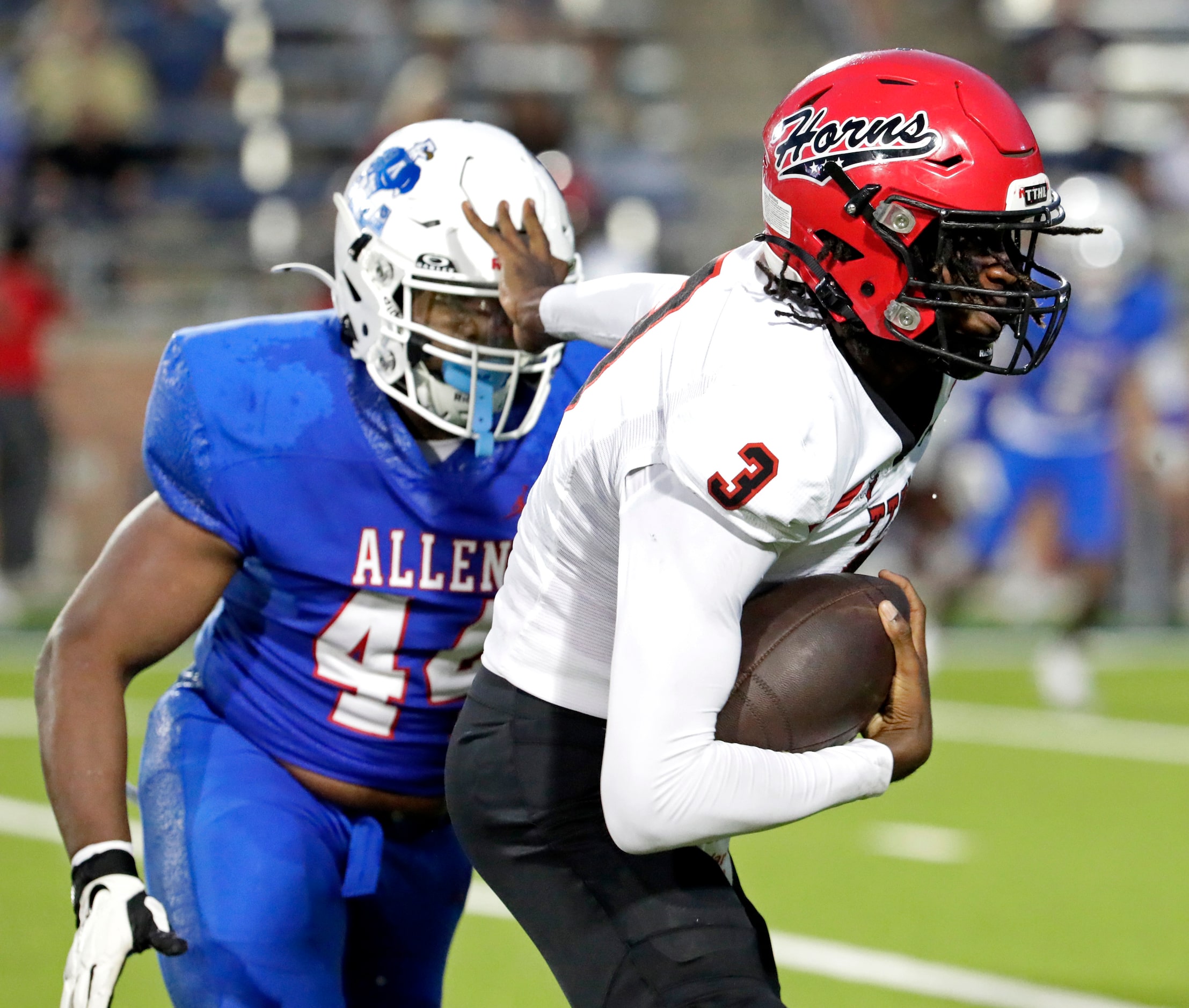 Cedar Hill High School quarterback Tamarion Crochett (3) puts a stiff arm on Allen High...