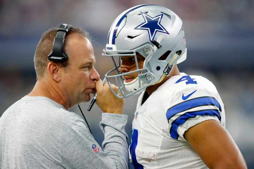 Dallas Cowboys offensive coordinator Scott Linehan (left) confers with rookie quarterback...