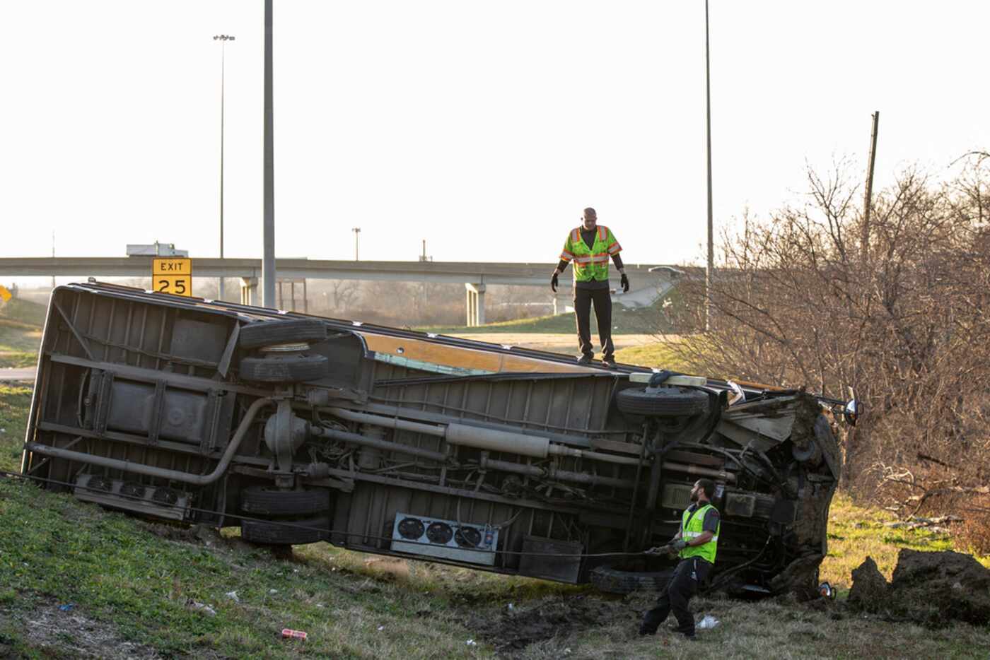 A workers attempt to turn a school bus from Bishop Dunne Catholic School that overturned in...