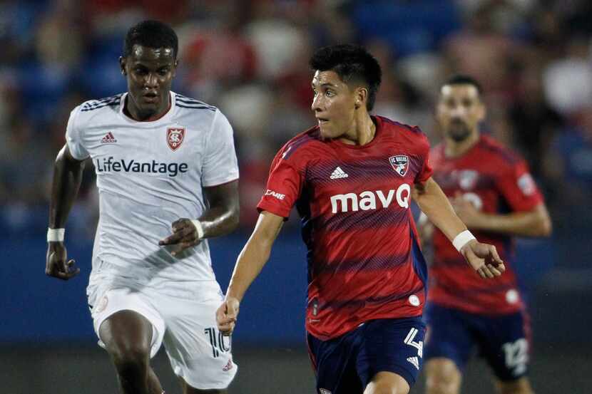 FC Dallas defender Marco Farfan (4) passes to a teammate as he is defended by Real Salt Lake...