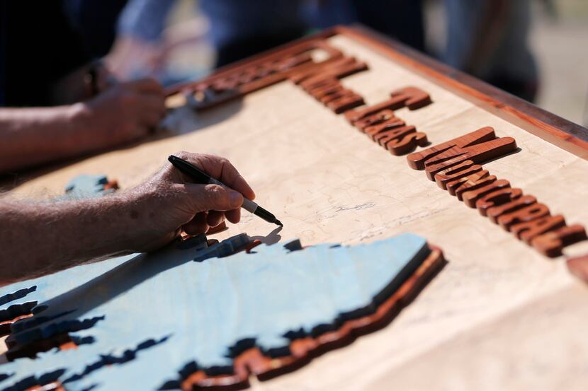Joe Joplin of the North Texas Municipal Water District signed a wooden likeness of a coming...