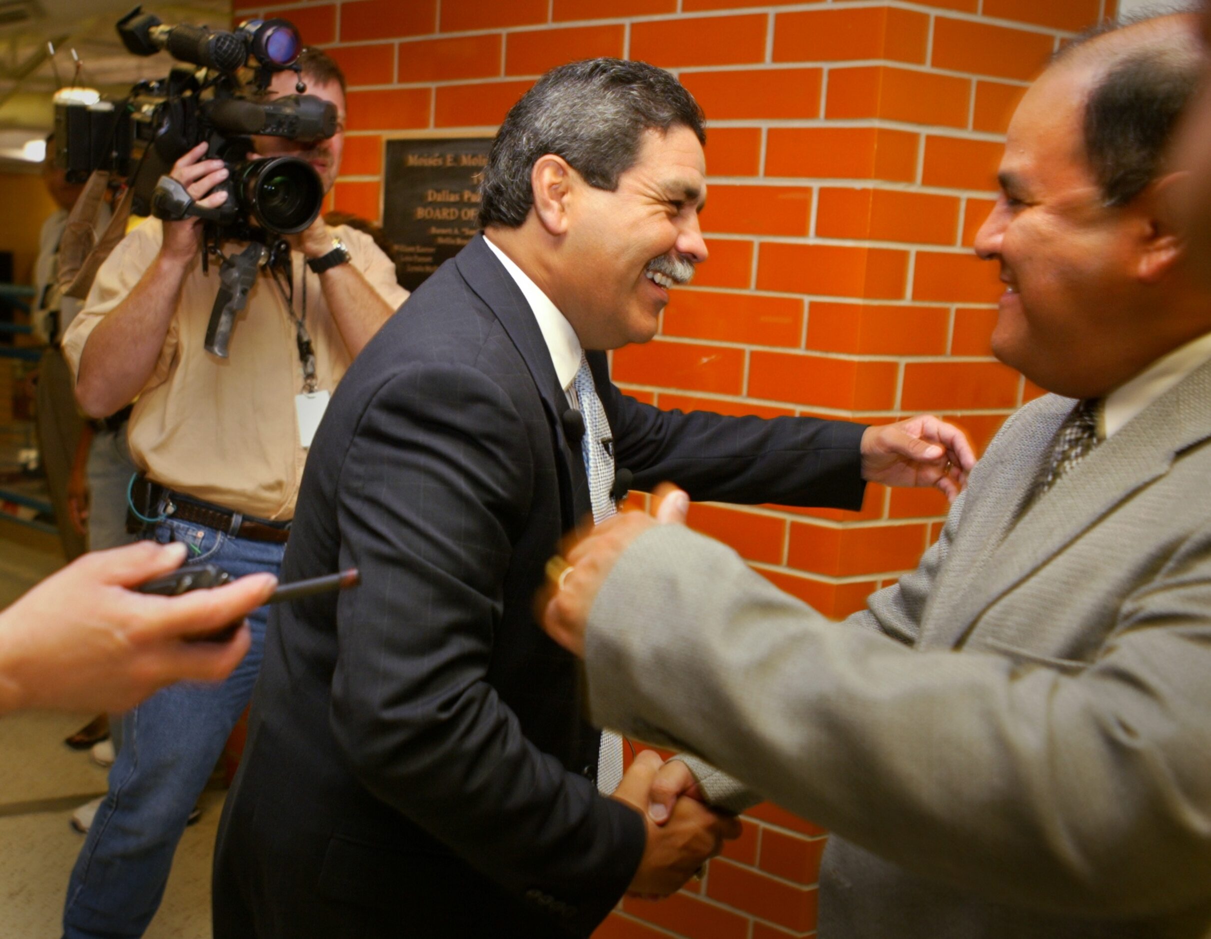 Superintendent Michael Hinojosa gives an abrazo to Tony Tovar -- an assistant principal at...