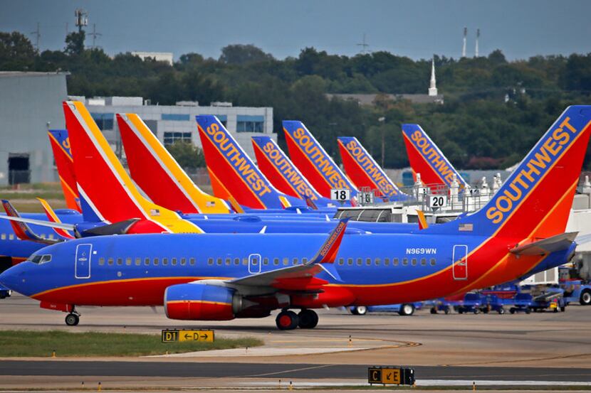 A Southwest Airlines airplane taxis past other Southwest Airlines airplanes at Love Field...