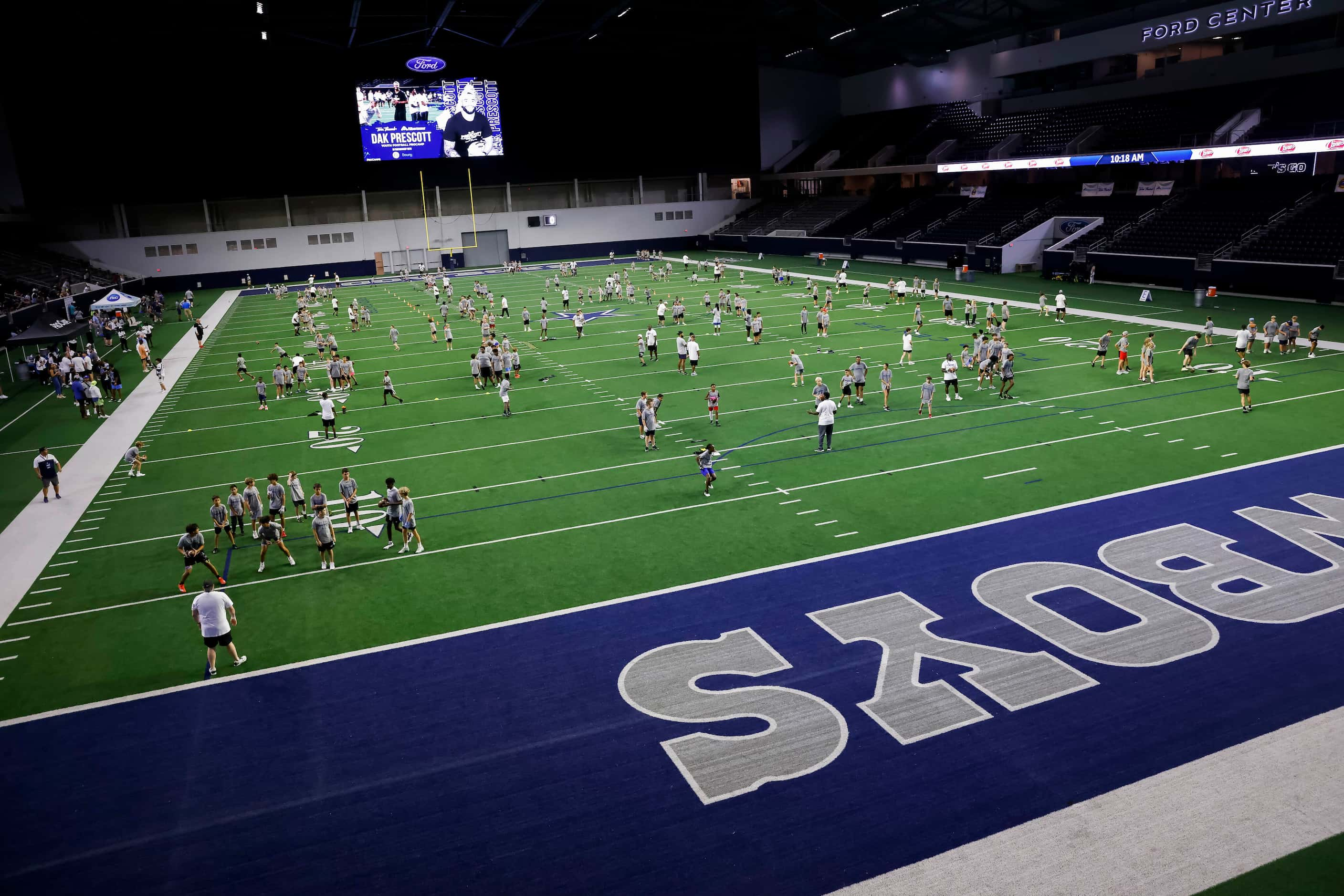 Cowboys quarterback Dak Prescott and local coaches work with students during the Tom Thumb...