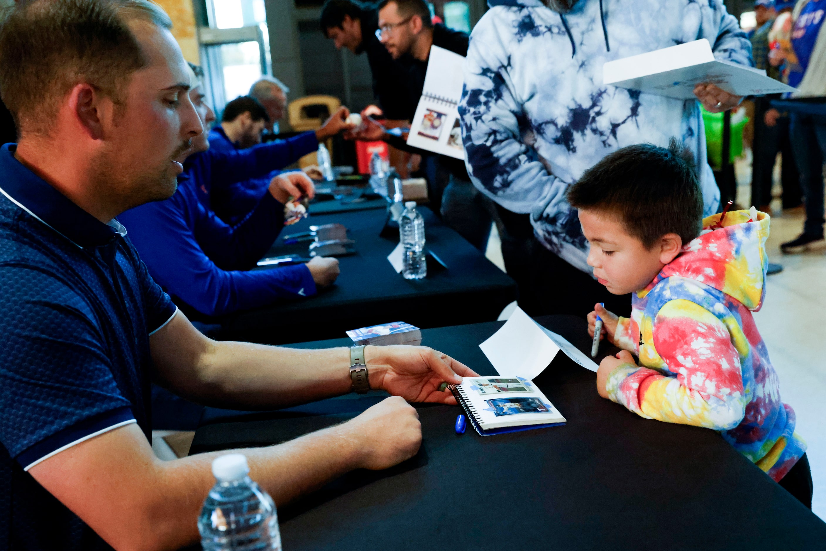 Texas Rangers first baseman Nathaniel Lowe asks Luca Lopez for the photo he wants to get an...