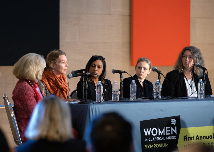 Five panelists from the 2019 Symposium sit together in discussion on a stage.