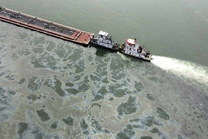 Marine fuel oil leaks into the Houston Ship Channel from a partially submerged barge after a...
