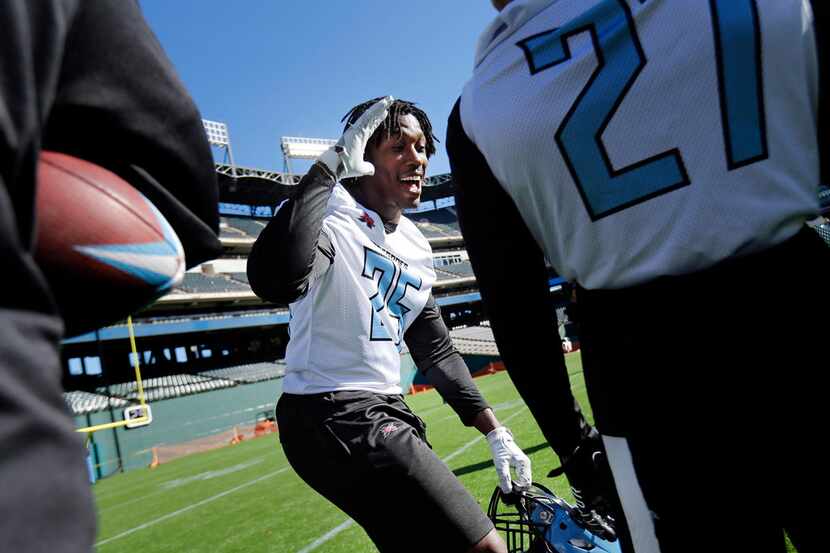 Dallas Renegades running back Lance Dunbar (25) laughs with teammates during a break in...