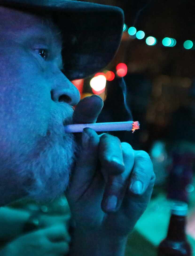 Bryan Price smokes at the bar at Ebeneezer's Pub and  Grill on Northwest Highway in Garland....
