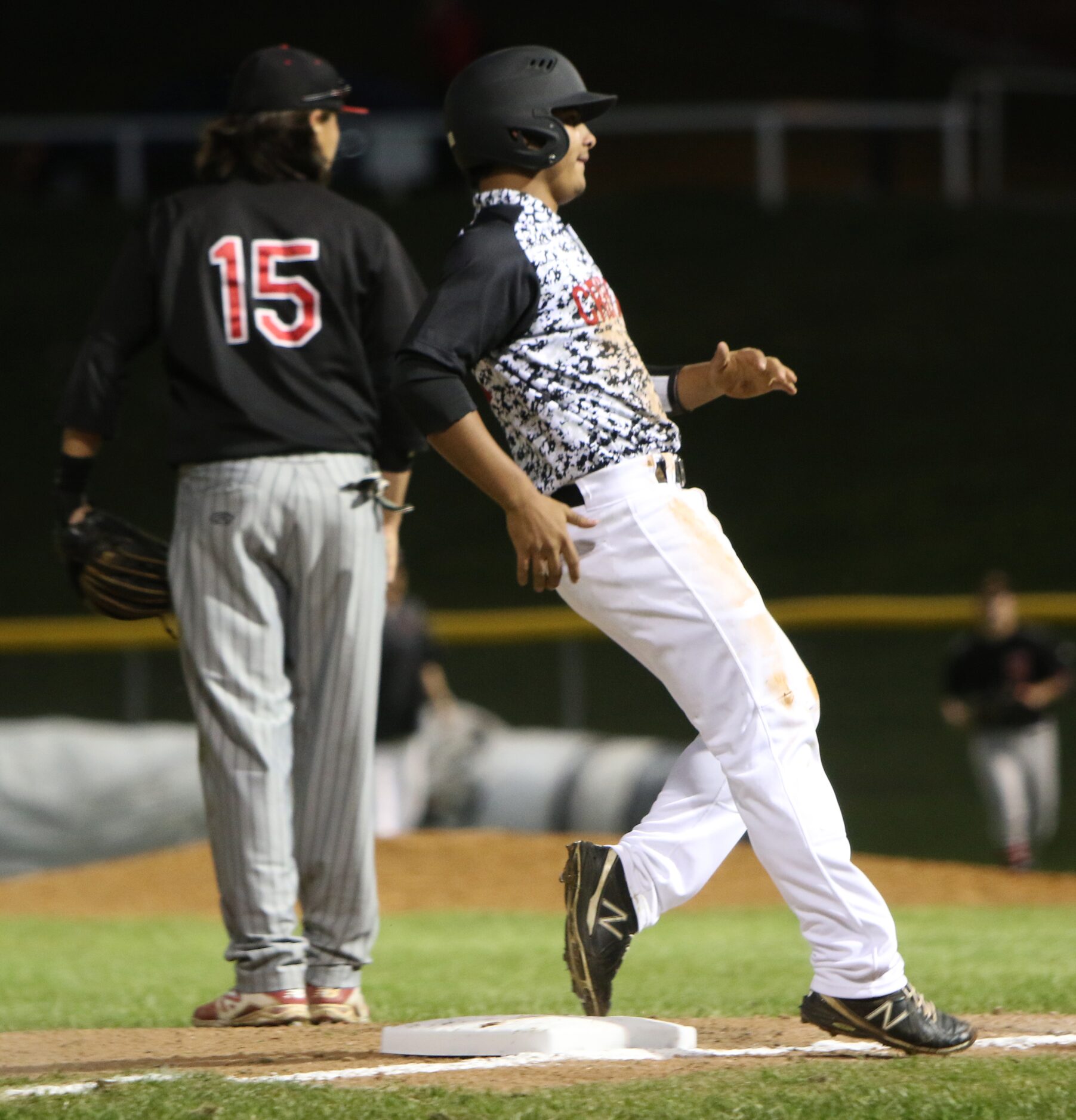 Carrollton Creekview's Raul Martinez (11) applies the brakes at third base after advancing...