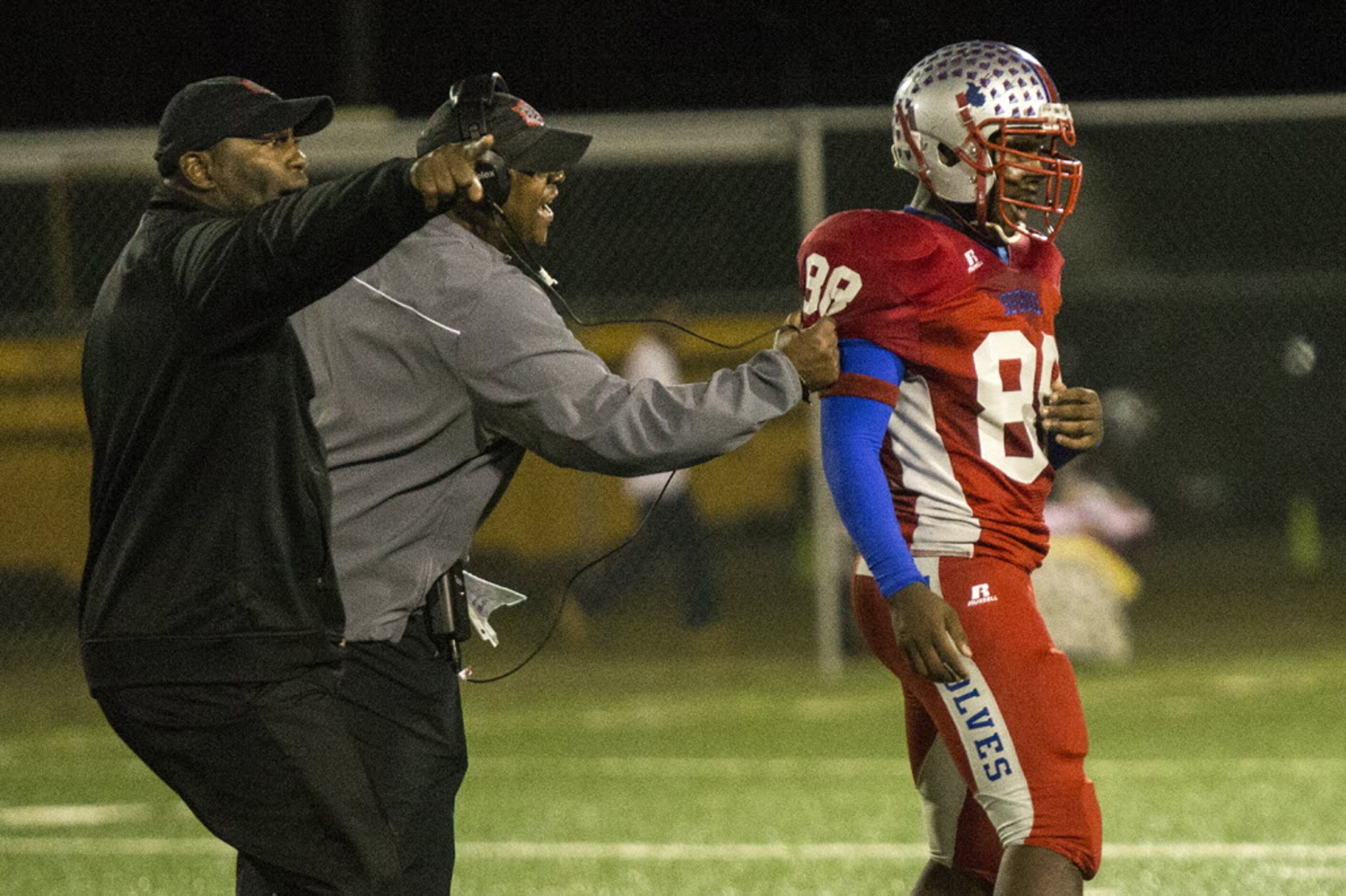 Spruce's Jamerius Kemp (8) is held back by the coaching staff as a scuffle breaks out during...