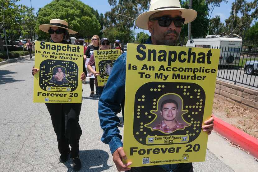 People opposed to the sale of illegal drugs on Snapchat participate in a rally outside the...