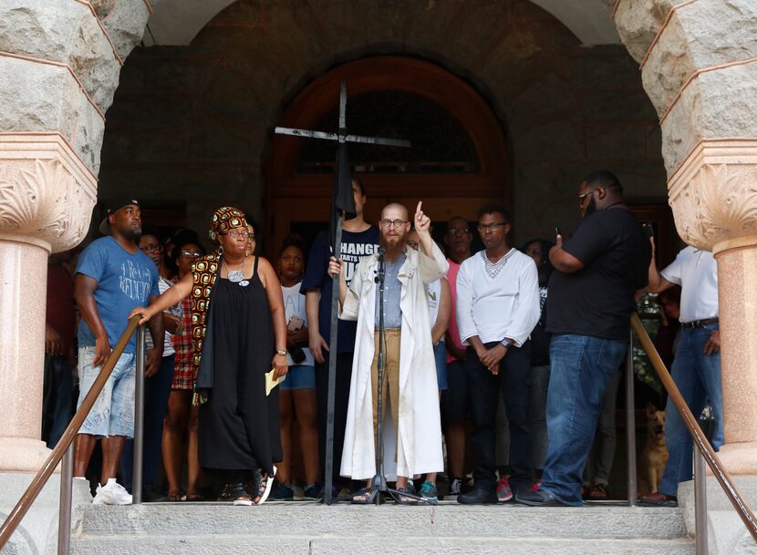 The Rev. Jeff Hood (center) and other protesters gathers on the steps on the Old Red Museum...