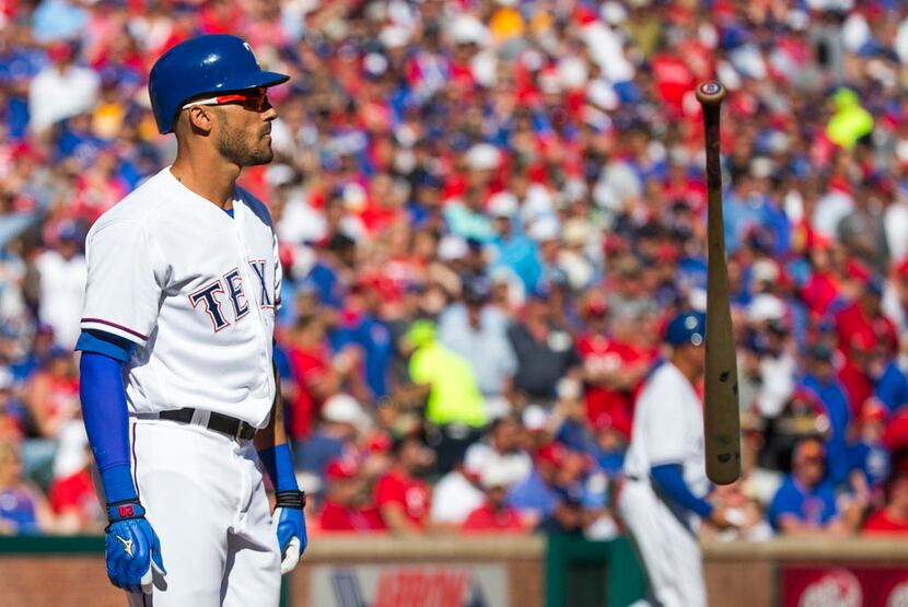 Texas Rangers outfielder Ian Desmond tosses his bat after he struck out with the bases...