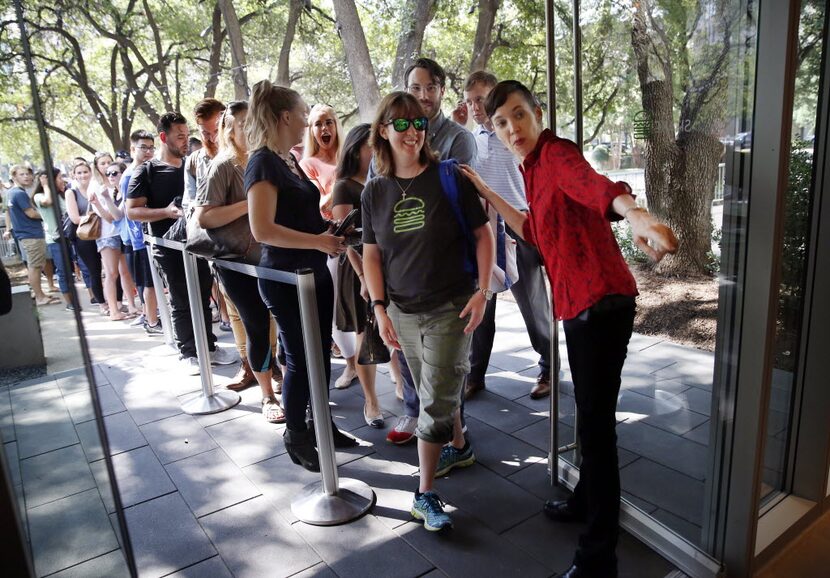 First customer Marisa Martinez (center) of Garland is shown where to order a burger after...