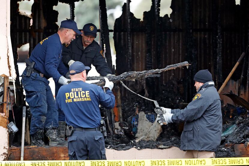 Fire marshals move debris while investigating the cause of a deadly fire Nov. 8, 2018, near...
