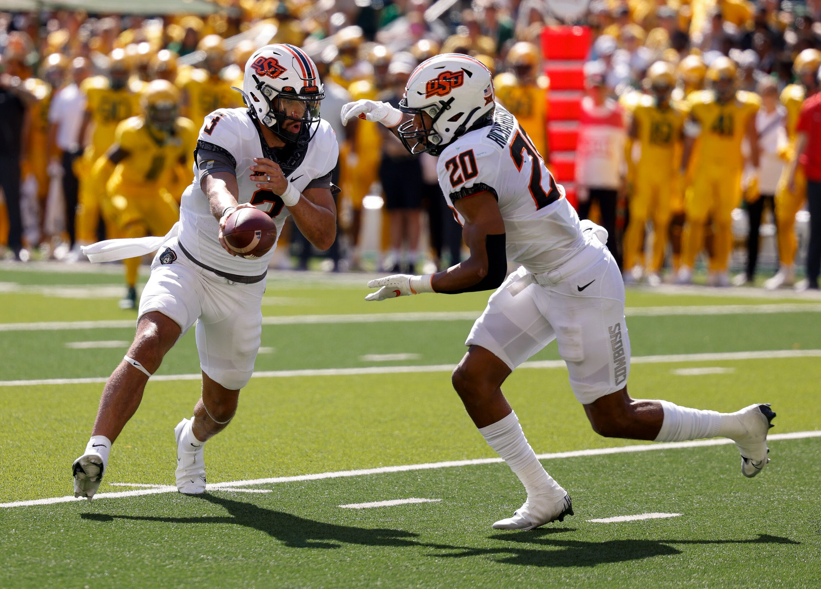 Oklahoma State quarterback Spencer Sanders (3) hands the ball to running back Dominic...