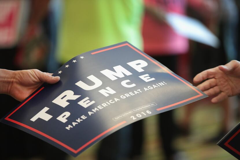 GREEN BAY, WI - OCTOBER 17:  A volunteer hands out signs before the start of a campaign...