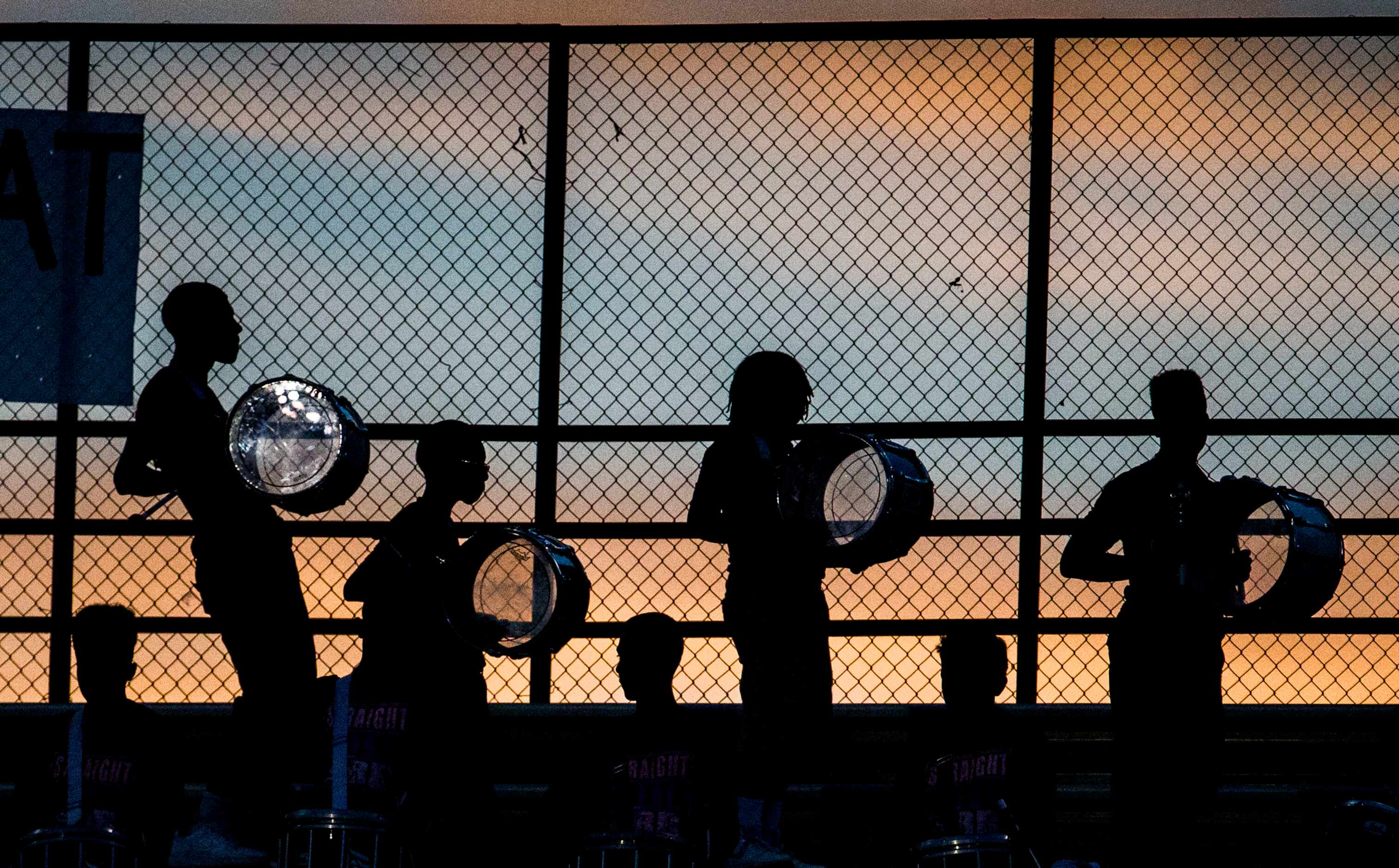 The Skyline drum line is silhouetted against the sunset during the first quarter of their...